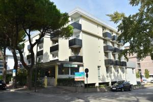 - un bâtiment blanc avec balcon dans une rue dans l'établissement Hotel Golf ***S, à Bibione