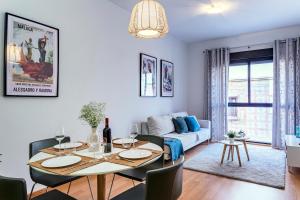 a living room with a table and a couch at -MalagaSunApts- Rooftop Pool in Málaga