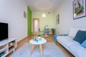 a living room with a white couch and a table at -MalagaSunApts- Rooftop Pool in Málaga