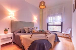 a bedroom with a bed with a tray on it at -MalagaSunApts- Rooftop Pool in Málaga +17 photos