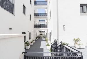 a corridor of a building with stairs and plants at -MalagaSunApts- Rooftop Pool in Málaga