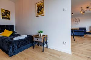 ein Schlafzimmer mit einem Bett und einem Tisch sowie ein Wohnzimmer in der Unterkunft Panorama Capital Black in Rzeszów