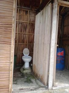 a white toilet sitting inside of a barn at Marine homestay in Fam
