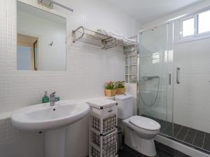 ein Bad mit einem Waschbecken, einem WC und einer Dusche in der Unterkunft Tunos 83 in Maspalomas