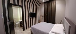ナポリにあるNeapolis Lifestyleのベッドルーム(ベッド1台、鏡、テレビ付)
