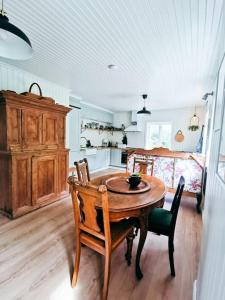 uma cozinha com uma mesa de madeira e cadeiras num quarto em Romantic farmhouse with idyllic garden em Bamble