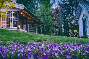 um jardim com flores roxas em frente a uma casa em Romantic farmhouse with idyllic garden em Bamble