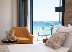 a hotel room with a bed and a view of the ocean at Seasabelle Hotel near Athens Airport in Artemida