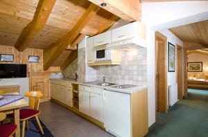 a kitchen with white cabinets and a table in a room at Hof am Arlberg - Familie Walter in Sankt Anton am Arlberg +18 photos