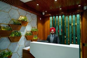 a man with a red hijab sitting at a desk at Hotel Global Inn by T&G in Amritsar