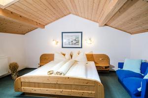 sypialnia z dużym łóżkiem i niebieską kanapą w obiekcie Hof am Arlberg - Familie Walter w mieście Sankt Anton am Arlberg