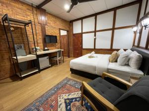 um quarto com uma cama, uma secretária e um sofá em Api-api Eco Chalet em Pantai Kok