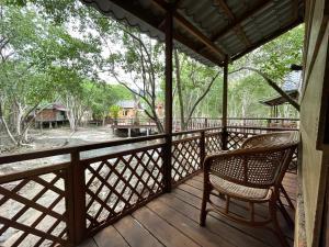 a porch with a chair and a view of a yard at Api-api Eco Chalet in Pantai Kok