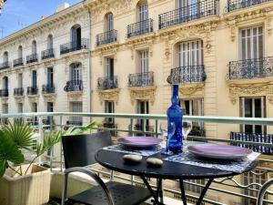 a table with plates and a blue bottle on a balcony at Magnificent apartment - Carré d'or in Nice