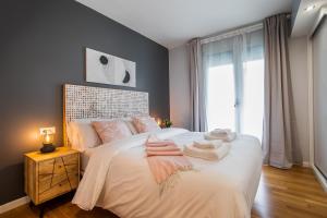 サン・アドリア・デ・ベソスにあるTendency Apartments Forumのタオルが敷かれたベッドのある寝室