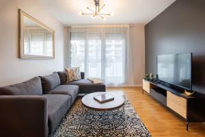 a living room with a couch and a flat screen tv at Tendency Apartments Forum in Barcelona