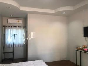 a bedroom with a bed and a wall with a television at Capital O 75412 V Resort in Nakhon Nayok