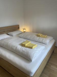 a large white bed with two yellow towels on it at Ferienwohnung Chalet Marienbrunnen in Oberstaufen