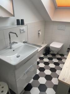 a bathroom with a sink and a toilet at Ferienwohnung Chalet Marienbrunnen in Oberstaufen