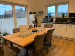 una cucina con tavolo e scatola di Watt n Meer Ferienhaus Sehestedt a Sehestedt