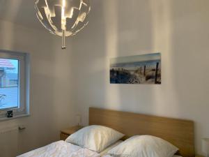una camera da letto con un letto e un lampadario di Watt n Meer Ferienhaus Sehestedt a Sehestedt