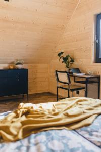 a bedroom with a bed and a table and chairs at LasHouse - Nowoczesna stodoła z widokiem na las in Bronków