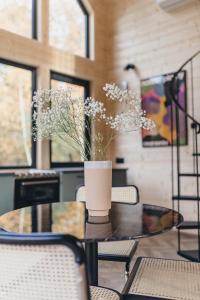 stół z wazonem kwiatów w obiekcie LasHouse - Nowoczesna stodoła z widokiem na las w mieście Bronków