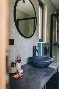 ein Badezimmer mit einem großen Waschbecken und einem Spiegel in der Unterkunft LasHouse - Nowoczesna stodoła z widokiem na las in Bronków