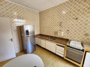 uma cozinha com um frigorífico e um lavatório em Apartamento 3 quartos , vista ao mar, Pitangueiras , 8 pessoas , 50 metros do mar no Guarujá