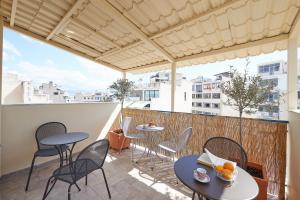 d'une terrasse avec des tables et des chaises sur un balcon. dans l'établissement Wake up with Acropolis view!, à Athènes
