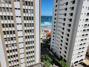 uma vista para a praia entre dois edifícios em Apartamento 3 quartos , vista ao mar, Pitangueiras , 8 pessoas , 50 metros do mar no Guarujá