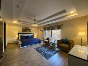 a bedroom with a bed and a couch and chairs at *Designer’s Luxurious 1BHK at Top Location of Twin Cities!! in Rawalpindi