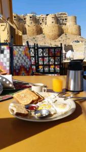 a plate of food with eggs and toast on a table at Shanti Home in Jaisalmer