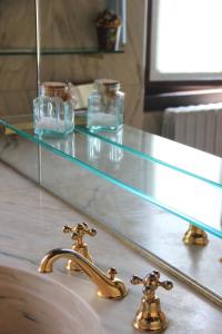 a bathroom sink with a glass counter top and a faucet at VILLA ADRIANA Varese - camere e appartamenti in Varese
