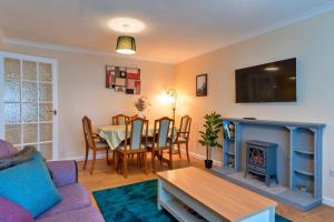 uma sala de estar com um sofá, uma mesa e uma lareira em Finest Retreats - Southern Lea em Burnham on Sea