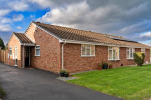 a red brick house with a green lawn at Finest Retreats - Southern Lea in Burnham on Sea