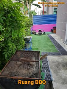 un jardín con parrilla y mesa de picnic en un edificio en 5Room Home2stay Hayyan Muslim Pool, en Melaka