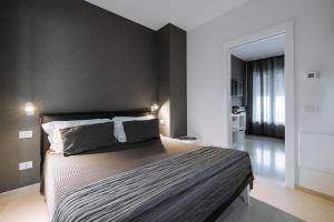1 dormitorio con 1 cama grande y pared negra en Suite1212 - Rattazzi, en Monopoli