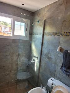 a bathroom with a shower and a toilet and a sink at Aqua Duplex in Villa Carlos Paz +11 photos
