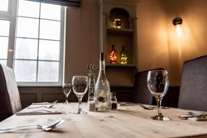 a table with wine glasses and a bottle on it at The Thorold in Marston