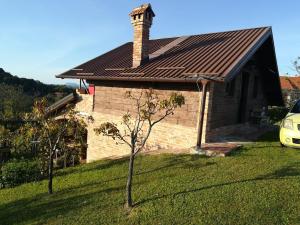 une petite maison en briques avec une cheminée et deux arbres dans l'établissement Holiday house Green hill in Zagorje, 