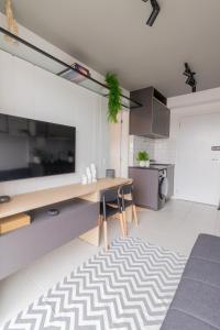 a kitchen with a desk and a table with a rug at O melhor da studio da região! in São Paulo