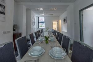 una lunga sala da pranzo con un lungo tavolo e sedie di Midwood Lodge a Manchester