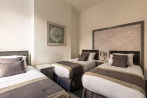 una habitación de hotel con 2 camas y un cuadro en la pared en Midwood Lodge en Mánchester