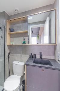 une salle de bain avec toilettes, lavabo et miroir dans l'établissement O melhor da studio da região!, à São Paulo 18 autres photos