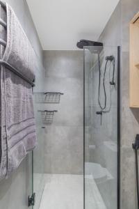 um chuveiro com uma porta de vidro na casa de banho em O melhor da studio da região! em São Paulo