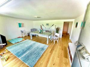 a living room with a table and a blue rug at 100m2 Haus am See & Wald mit 1200m2 Garten in Schwielowsee