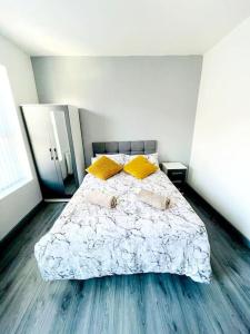 a bedroom with a large bed with yellow pillows at 8 Guest Lovely home in Liverpool in Liverpool