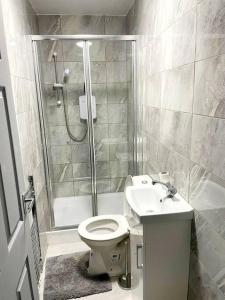 a bathroom with a toilet and a shower and a sink at 8 Guest Lovely home in Liverpool in Liverpool