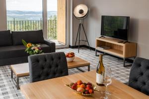 Kazalnica Family&Conference Resort في سوسنوفكا: غرفة معيشة مع طاولة مع زجاجة من النبيذ